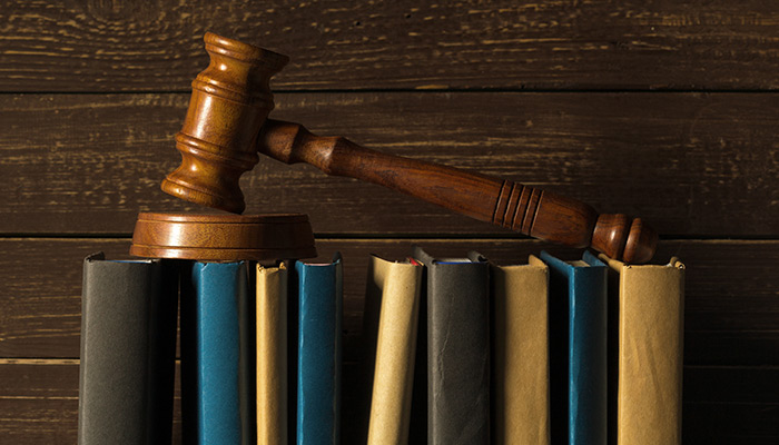 Gavel With Books On Old Wooden Desk