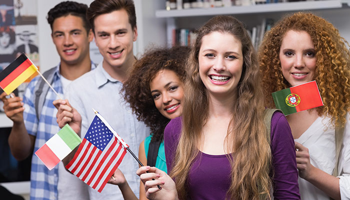 Diverse group of students waving international flags