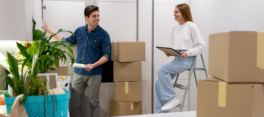 young couple packing items for moving and discussing how much do movers cost in Los Angeles