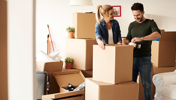 couple packing items in cardboard boxes