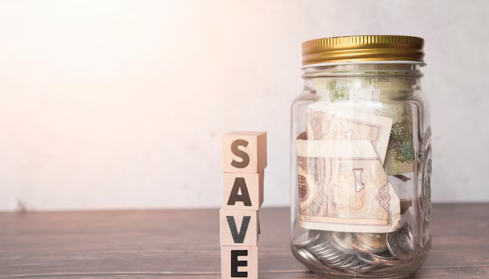 glass jar with save written on wooden block