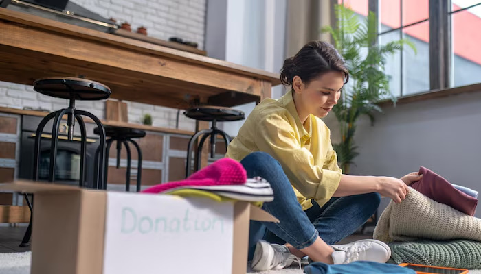 a woman decluttering clothes for donation